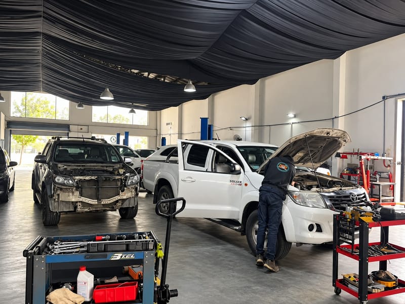 Técnico revisando el motor de una Toyota Hilux en el taller